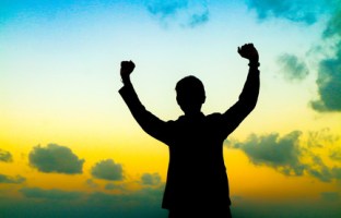 Silhouette of man showing his hand on sunset sky background, Successful business concept.