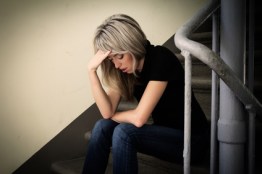 Depressed woman sitting on stairs